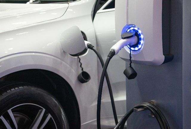 An electric vehicle charging through a charging station